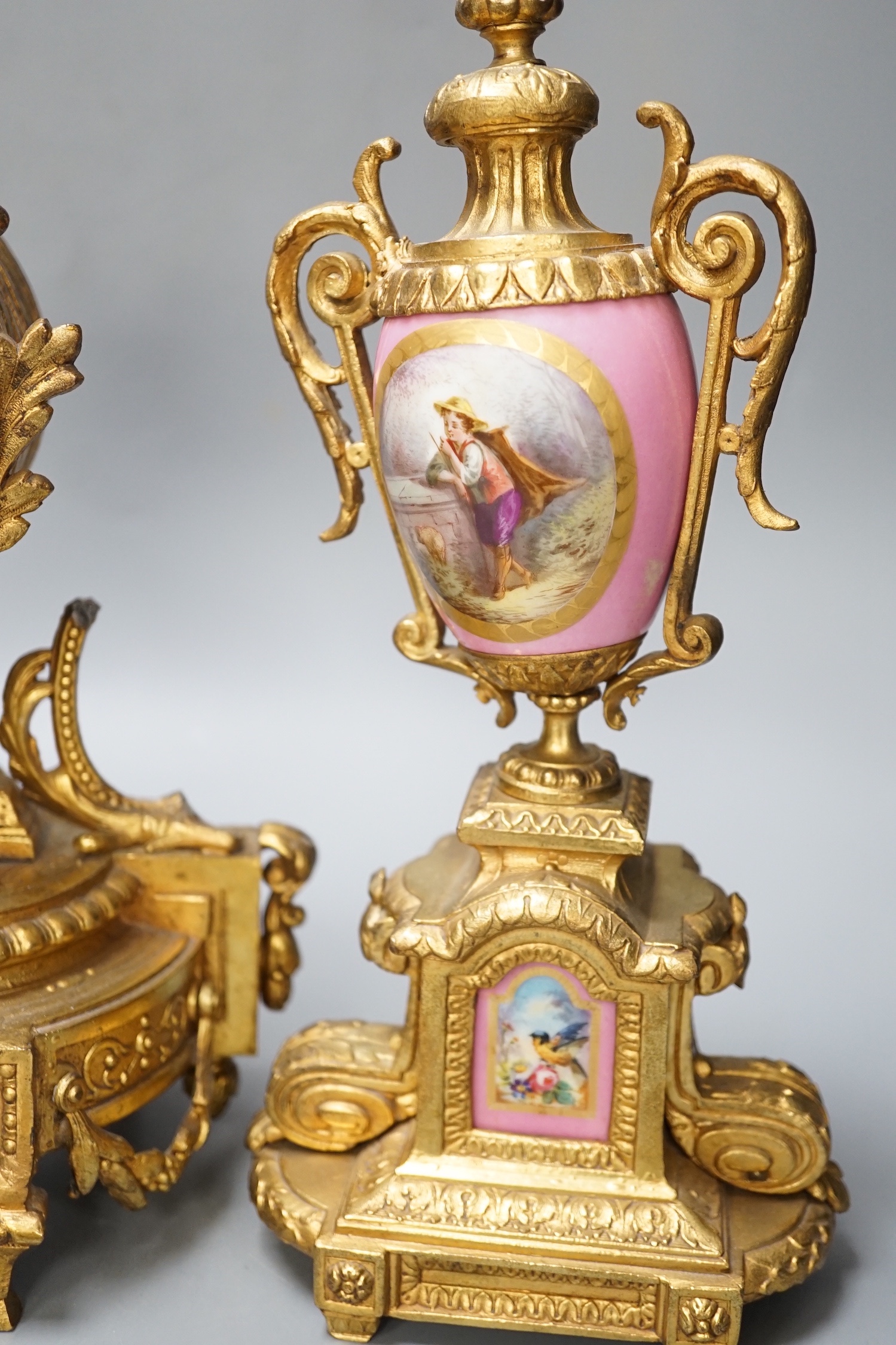 A French gilt metal and porcelain clock garniture. 36.5cm